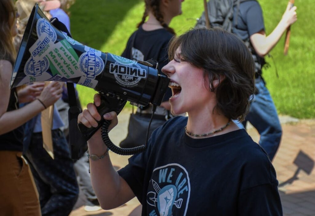 OSE Bargaining Committee Candidate Grace Rodriguez, speaking into a megaphone at the 2025 OSE Strike